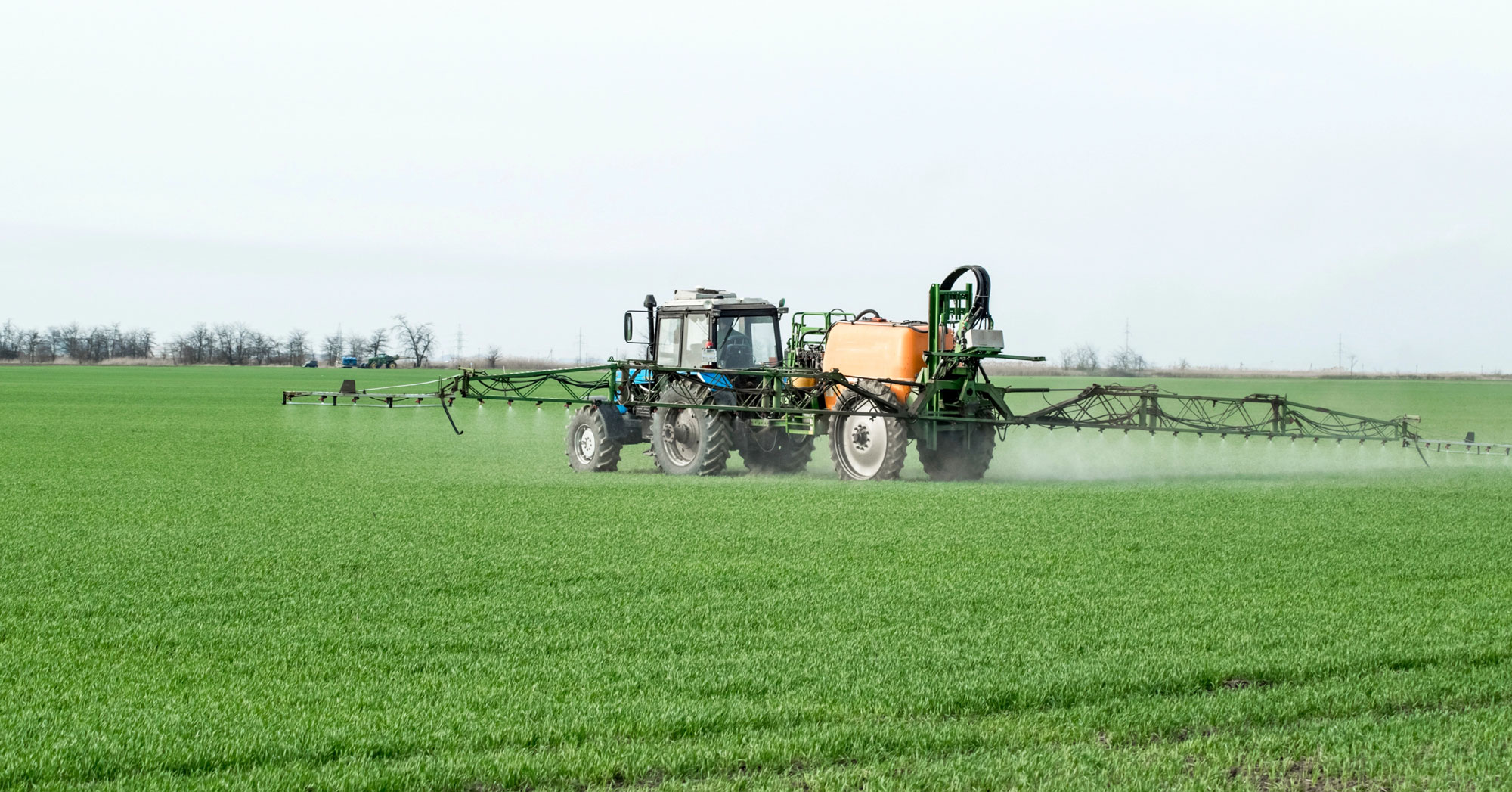 tractor spraying fertilizer in a field